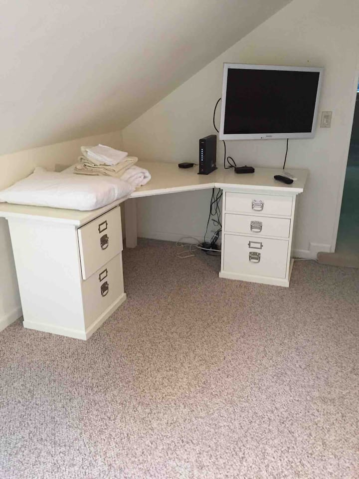 โต๊ะทำงานและทีวีจอแบนในห้องพร้อมดึงออกได้ขนาดควีนไซส์