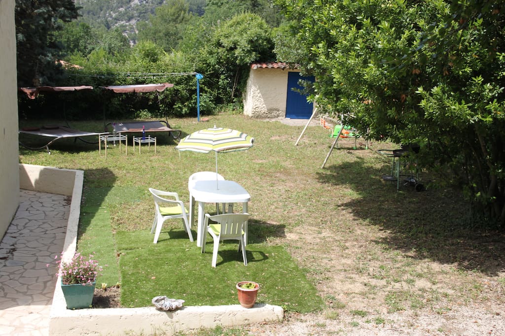 Jardin arboré privatif avec lits de soleil et espace enfants