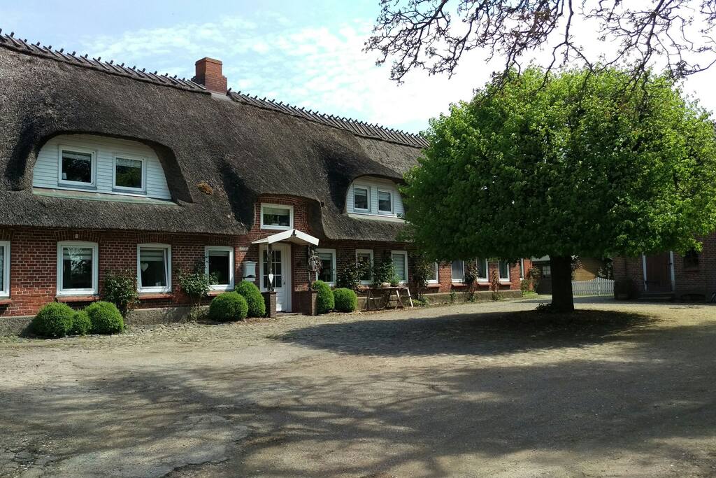 Wohnen unter Reet - Haupthaus mit Ferienwohnung und Hofplatz, auf dem ein Parkplatz für euch reserviert ist. (Mai 2017)
