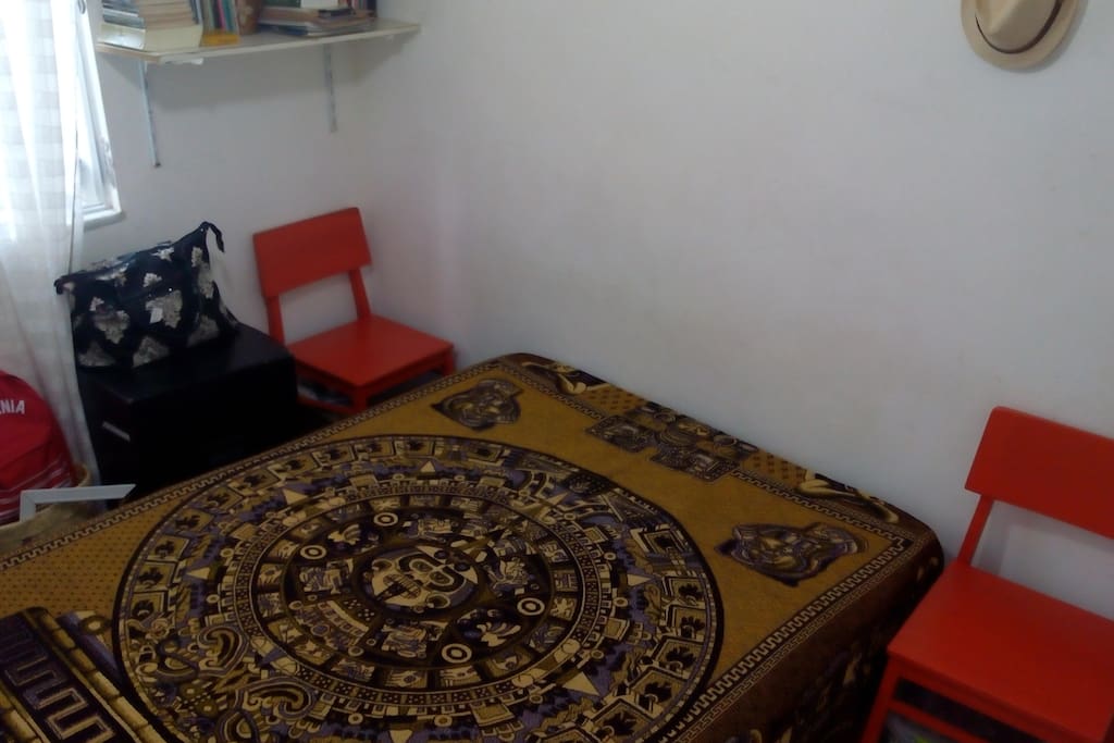 Esta é a foto do quarto que contem uma cama box, duas cadeiras, um guarda-roupa, estante com duas prateleiras e uma Tv.