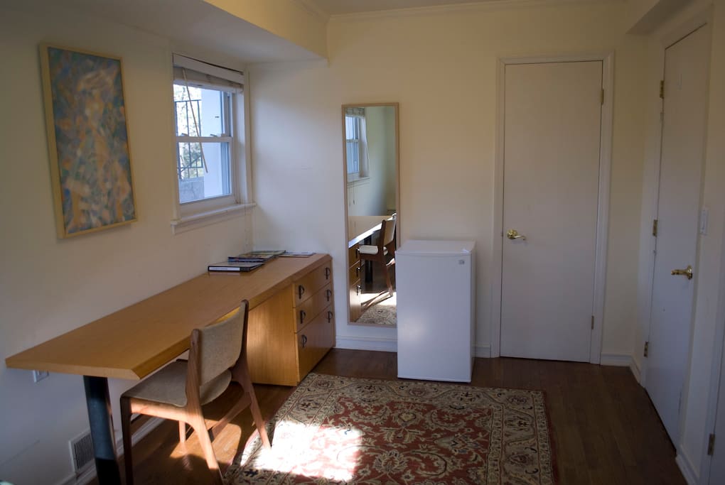 This guest room has a long desk, plus a small room fridge.