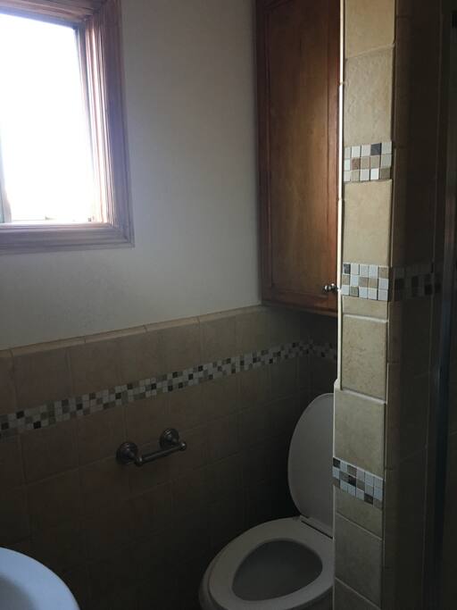 stoked cabinets with toilet paper, towels, and body wash.