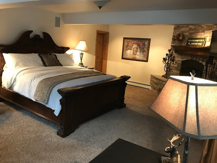 Dormitorio principal con baño privado, chimenea de gas y TV de pantalla plana. Acceso al arroyo y al jacuzzi a través de puertas correderas de vidrio francés.