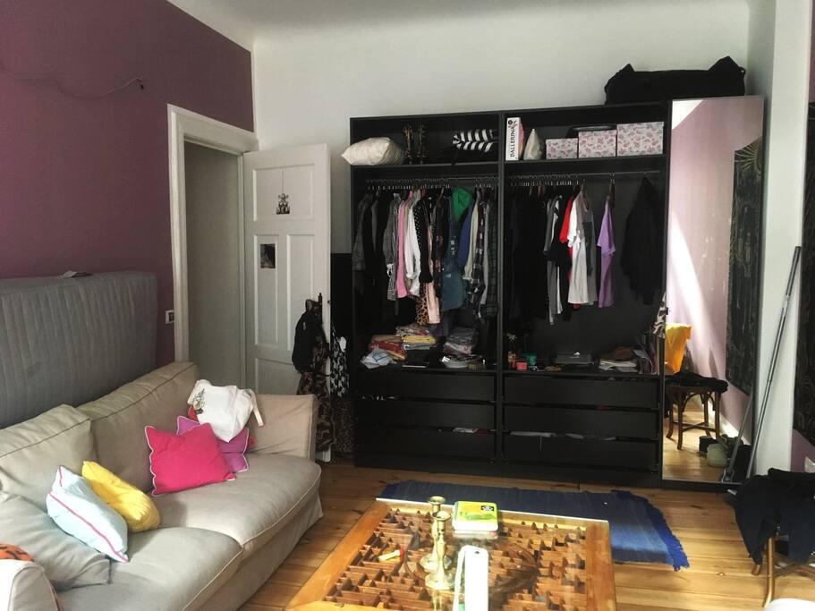 other view of the room with a spare mattress behind the couch