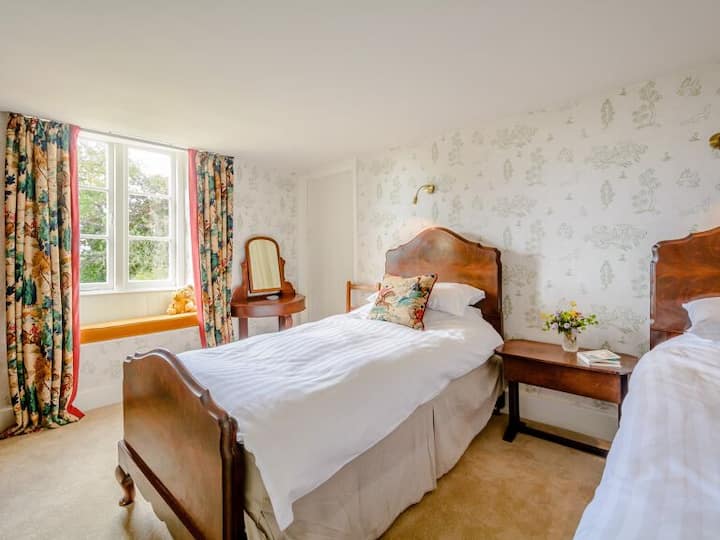 Delightful Wychwood twin room with Kit Kemp wallpaper and recycled Sanderson fabric from the original house makes a cosy twin room for children or friends alike.  Next to the Queens Room with door to landing and access to family bathroom.