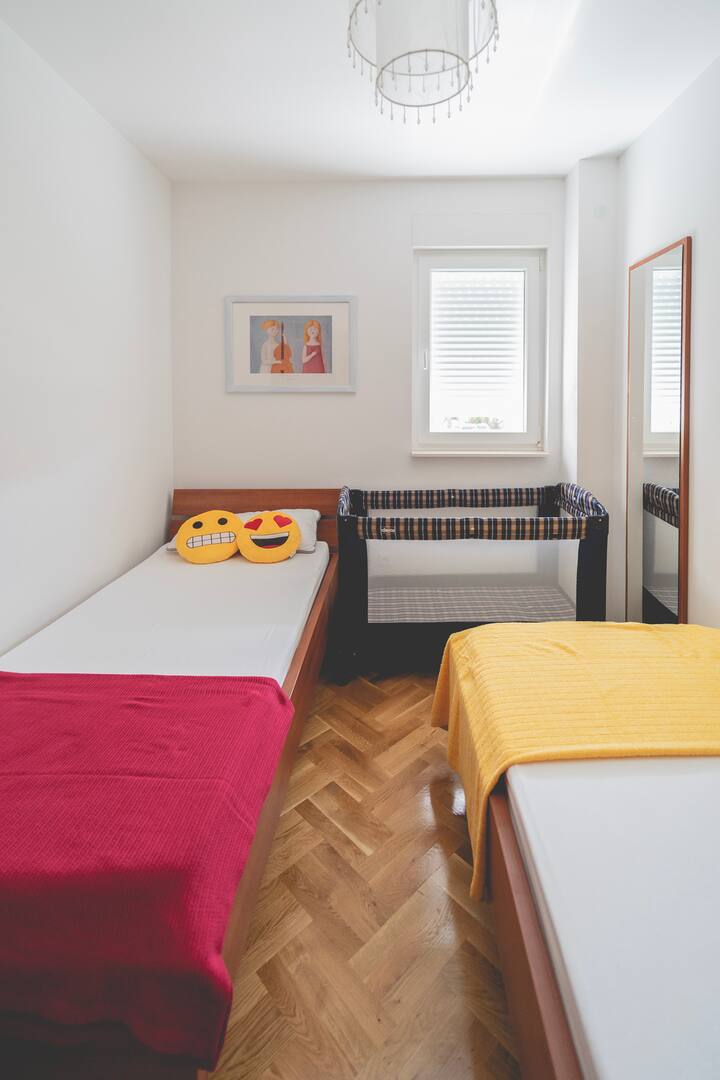 Chumba kidogo cha kulala na vitanda viwili vya mtu mmoja na kitanda cha mtoto. Kitanda cha mtoto kinaweza kuwekwa mahali pengine.