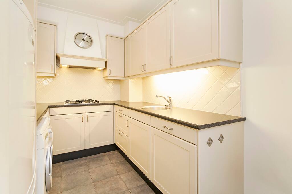 Moderne keuken met alle faciliteiten, waaronder een wasmachine, wasdroger, koelkast, diepvries, afwasmachine, magnetron, nespresso apparaat