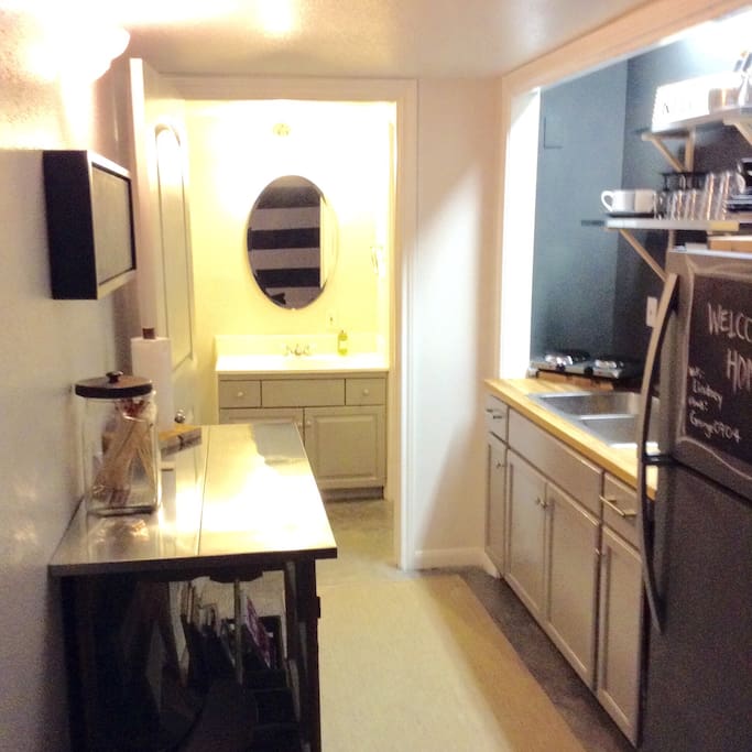 Kitchenette with 1400W burners, microwave oven, full sized fridge and sink. All covered in chalkboard to leave messages for guests.