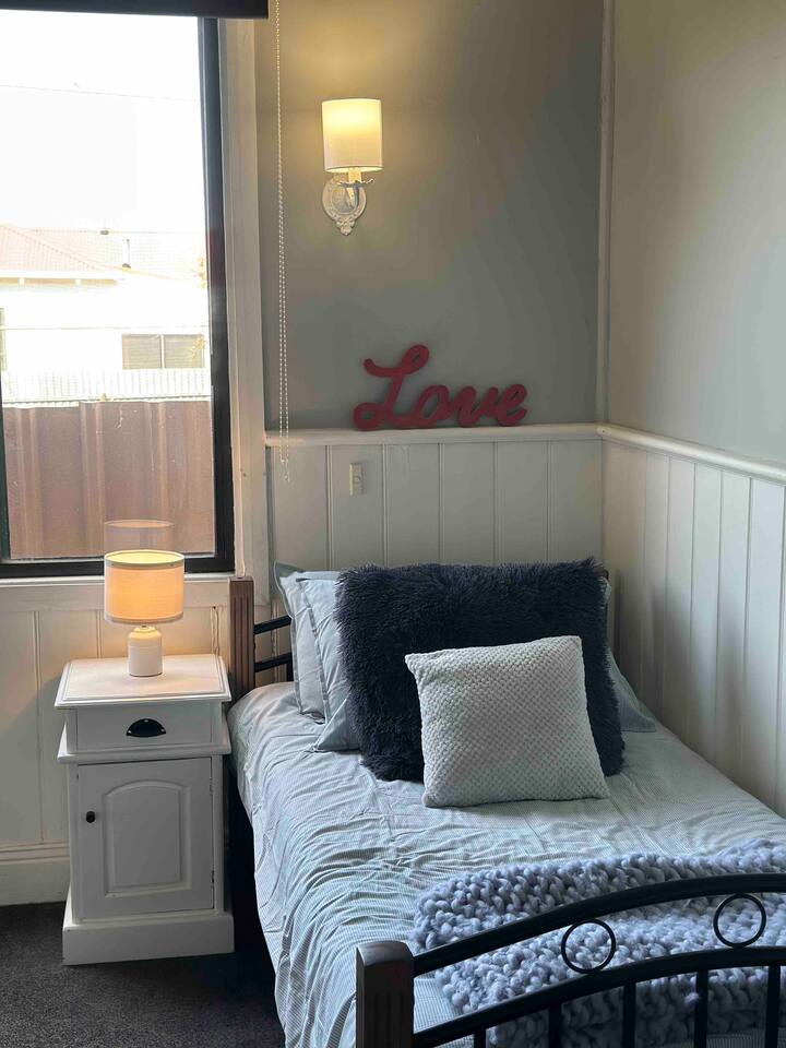 Our third bedroom features 2 cozy single beds adorned with tasteful linens. There is ample space for play making it a perfect space for young guests. There is a full sized wardrobe, some games, books and toys along with a gaming console and screen.