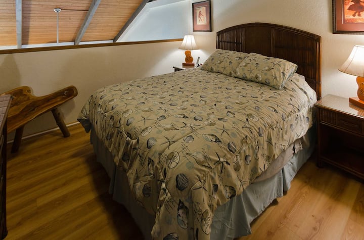 Loft bedroom #1 (Queen size bed) Please note the open air architectural design, common throughout Hawaii.  This takes advantage of the trade wind breezes cooling, should you desire, without the use of the central air-conditioner or ceiling fan. 