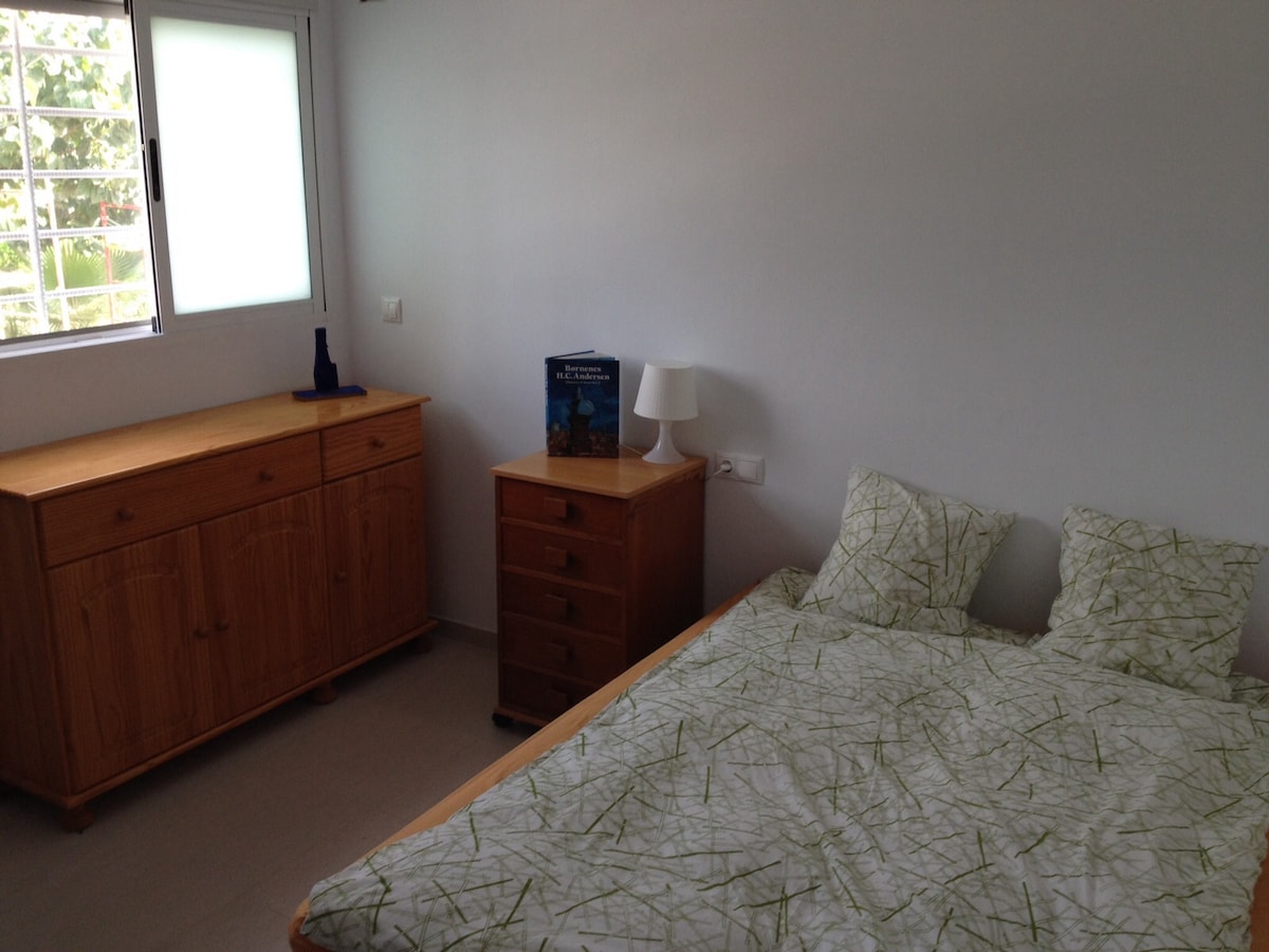 חדר עם מיטה זוגית ומיטת יחיד שנייה.