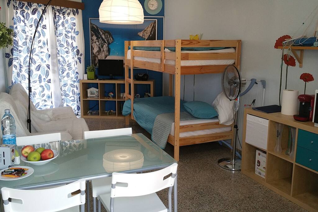 A small living room with a twin up-and-down bed and a sofa that converts into a bed also. There is an extra Air Condition unit here.