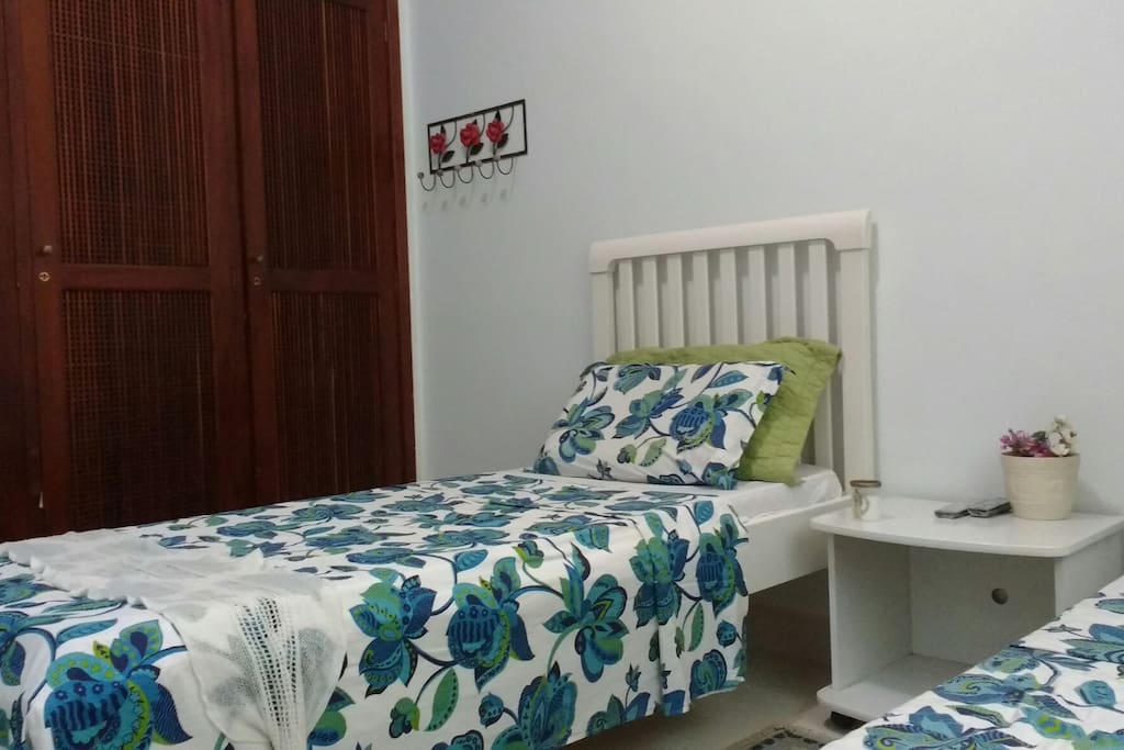 Essa cama fica mais próxima do guarda roupa e tem cabeceira.