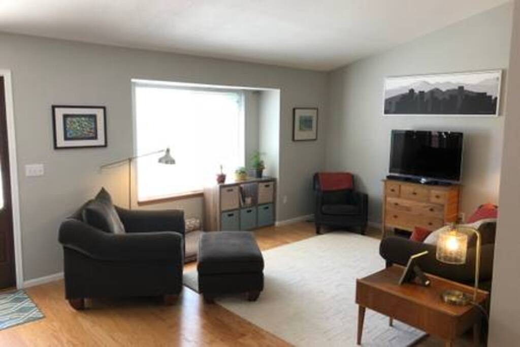 Bright, open comfortable main level living room with front door entrance