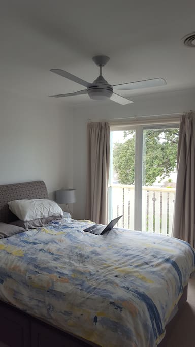 Main bedroom with fan and ducted AC, juliet balcony with city views