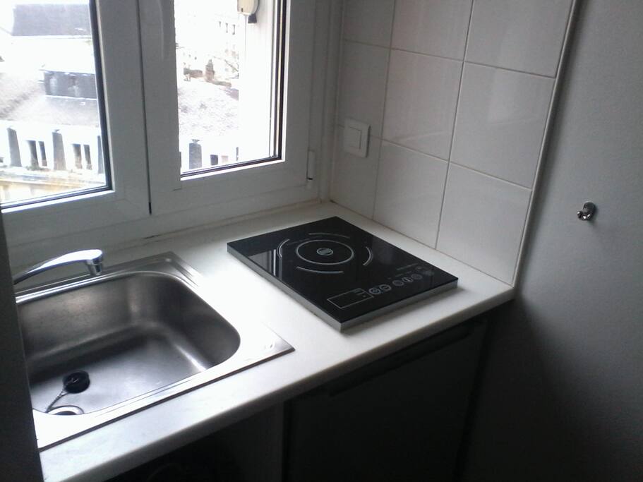cooking and fridge in front a lightly window