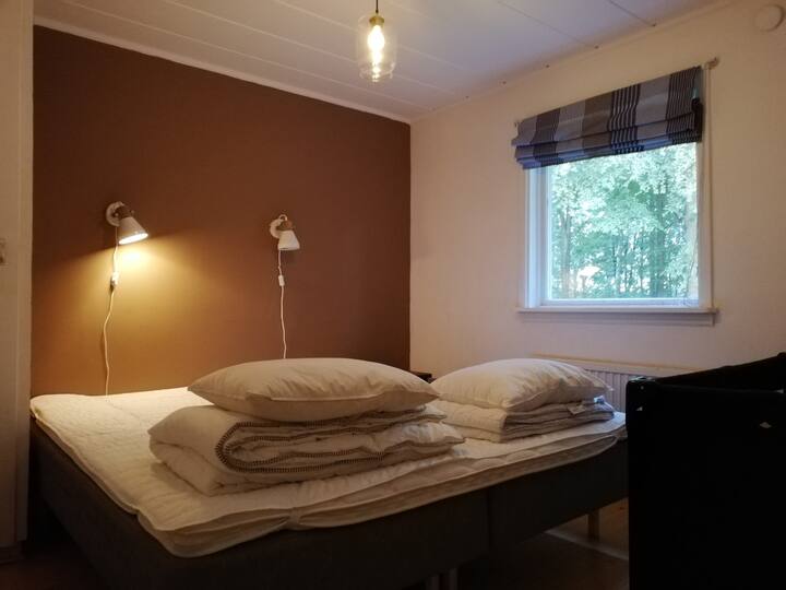 Bedroom with double bed and baby cot (cottage 1)