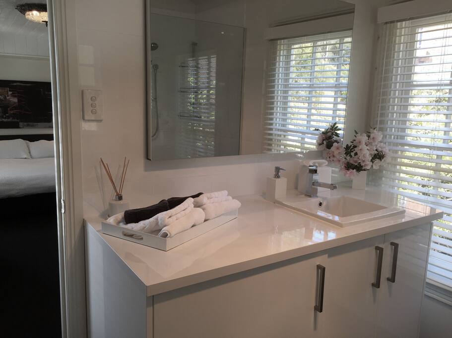 Light filled bathroom with washer/dryer in cupboard.