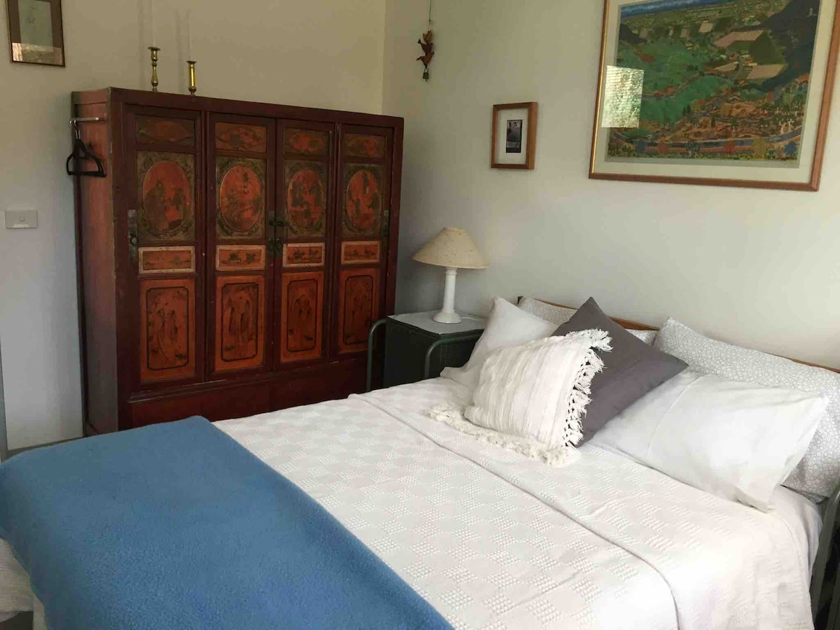 Hoofdslaapkamer met queensize bed en een oude Chinese kledingkast.