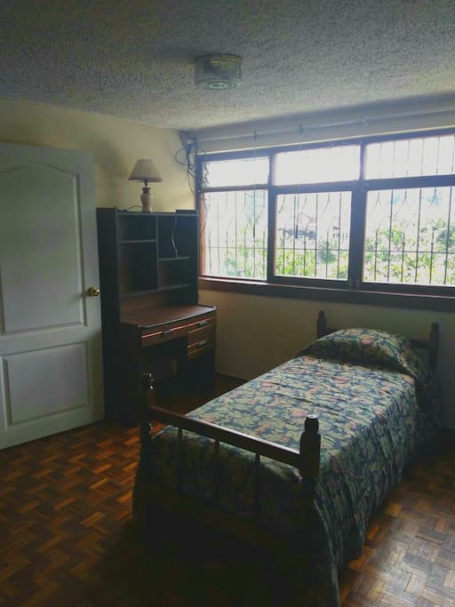 Dormitorio con cama de una plaza, escritorio y clóset