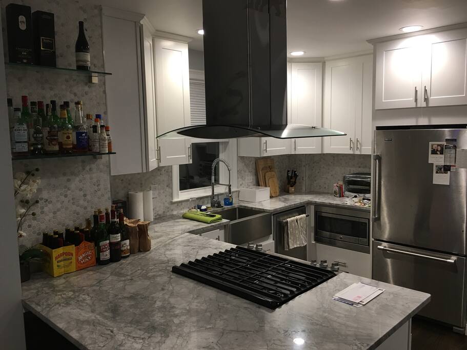 Kitchen and breakfast bar with three bar stools for seating.