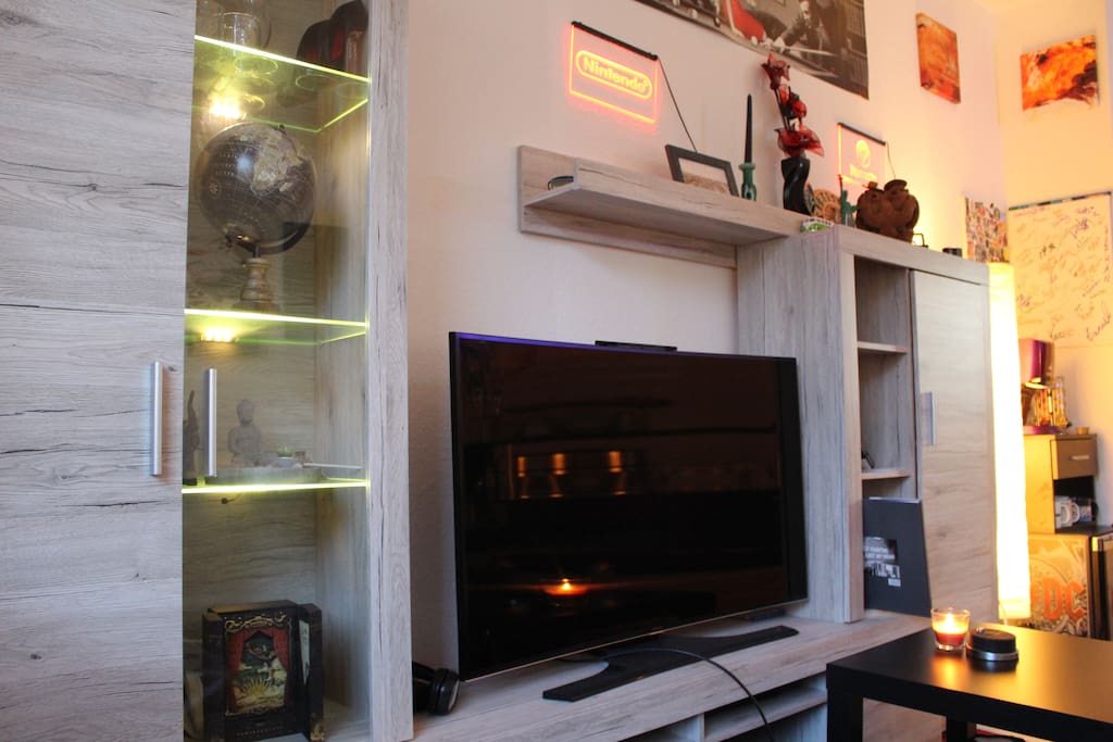 Wohnzimmer mit Couch, TV, Bar und Kaffeemaschine