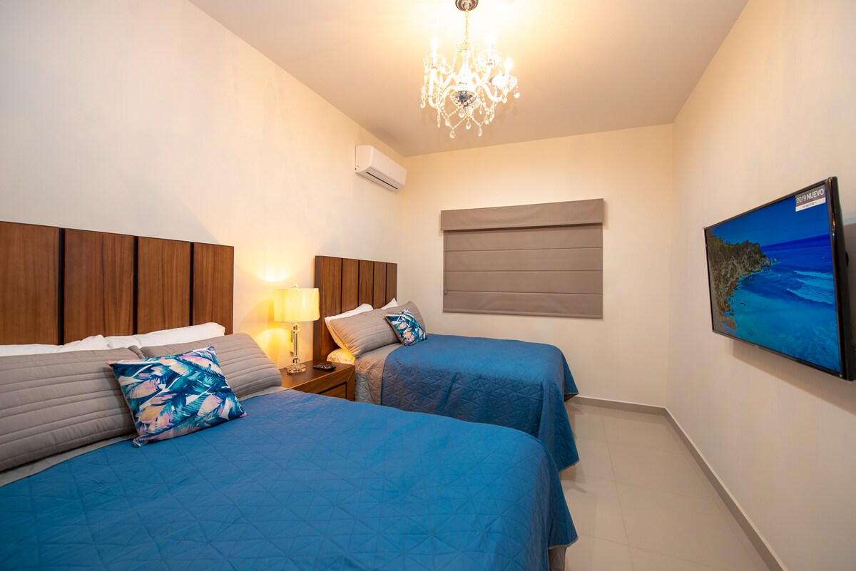 ห้องนอนรองพร้อมโคมไฟระย้าสุดหรูเตียงคู่ 2 หลังและ Smartv ขนาด 50 นิ้ว