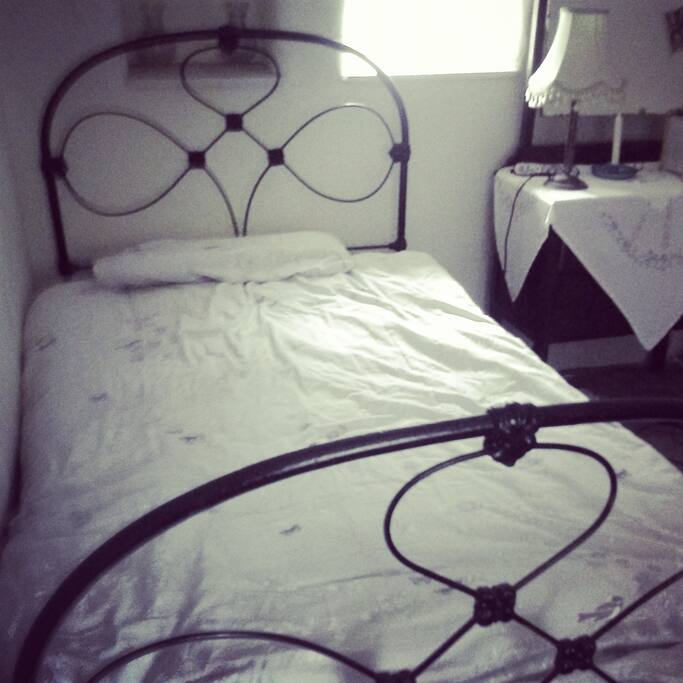 Single ground floor room, iron bedstead, dressing table and chest of drawers