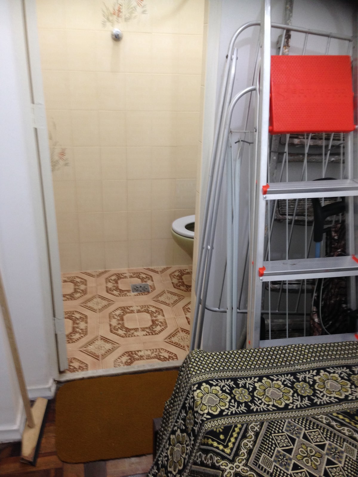 غرفة خلفية بسرير واحد وحبل ملابس وسلم