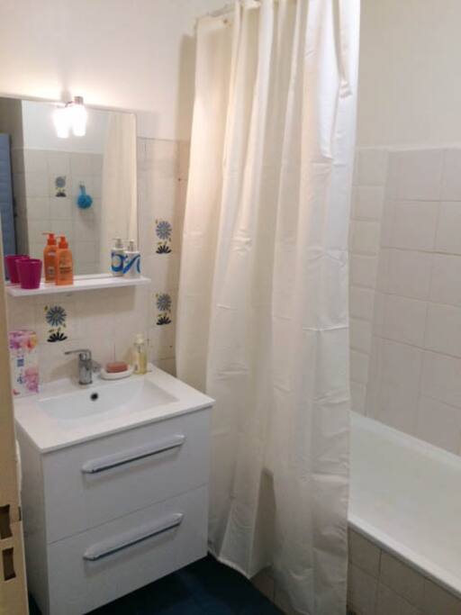 salle de bain avec baignoire et armoire de rangement