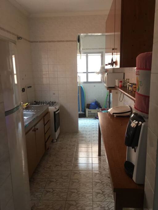 Cozinha e Lavanderia com utensílios e maquina de lavar.