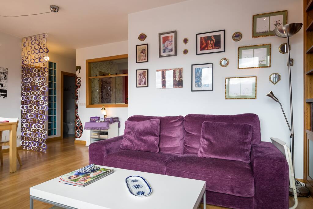 Este es el salón abierto. Sentaos por favor. En el sofá o en la butaca junto a la ventana.