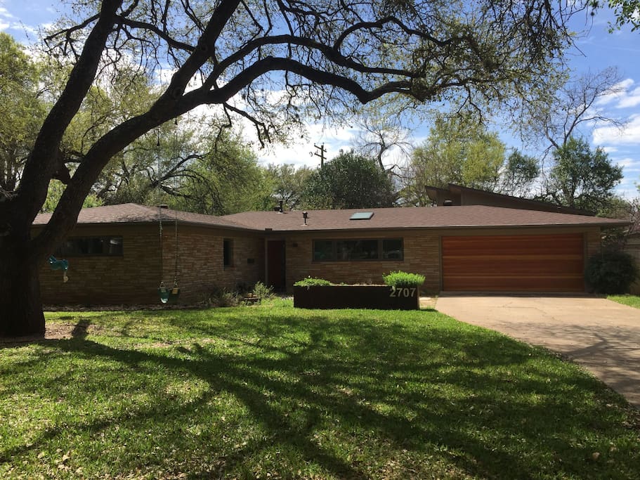 Front yard with huge oak tree and swings for infant and child
