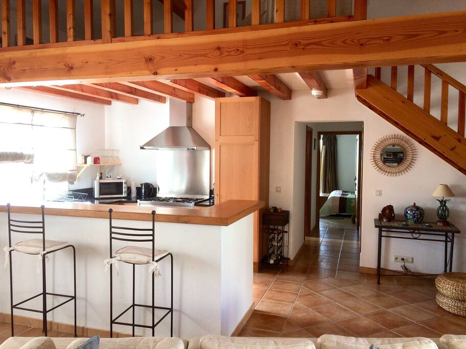 La cuisine sous la mezzanine et le couloir vers la chambre (il comporte salle d’eau et toilettes)