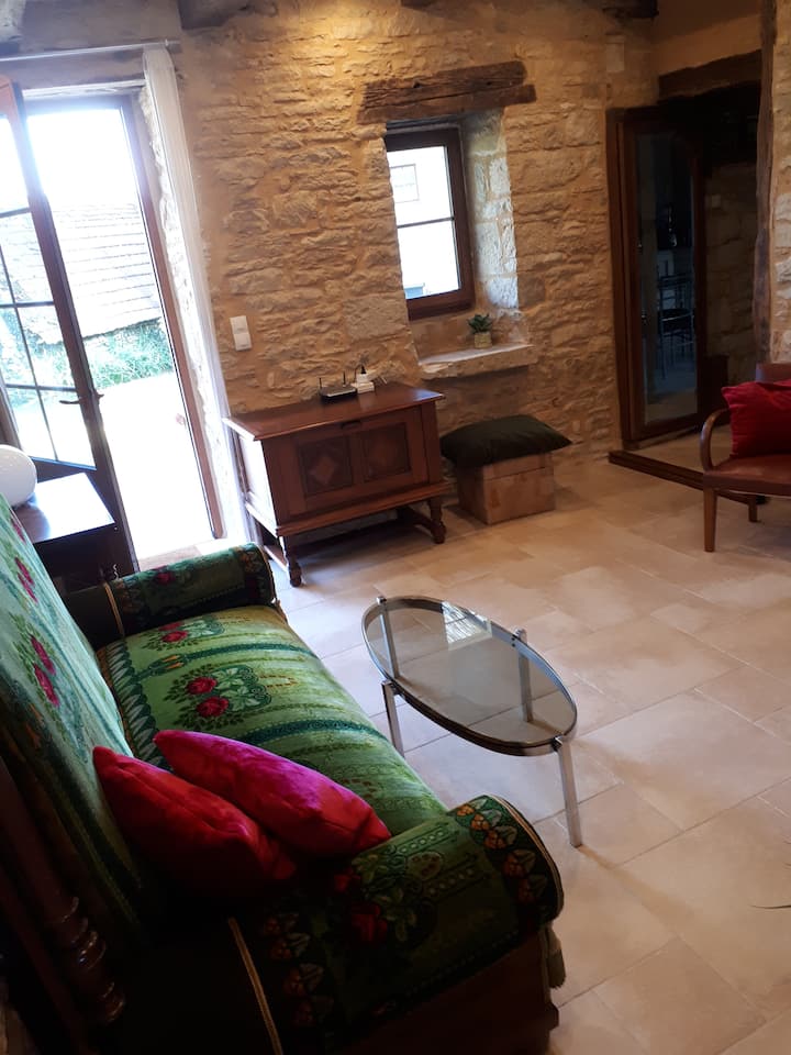 Vista del salón hacia la terraza: puerta  y pequeña ventana con mosquitera que da a la terraza de madera  y paso directo hacia la cocina, a la derecha. Entre los dos, la puerta con espejo se abre al cuadro eléctrico  + lugar para la aspiradora.