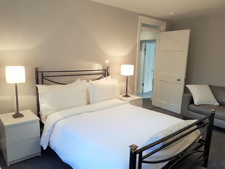 Bedroom with Queen bed, large sofa, and private patio