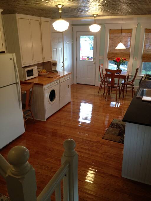 The redesigned space integrates cooking, dining, laundry, and storage while maintaining a feeling of openness. Surfaces are a mix of hardwood, tin, granite, and tile.
