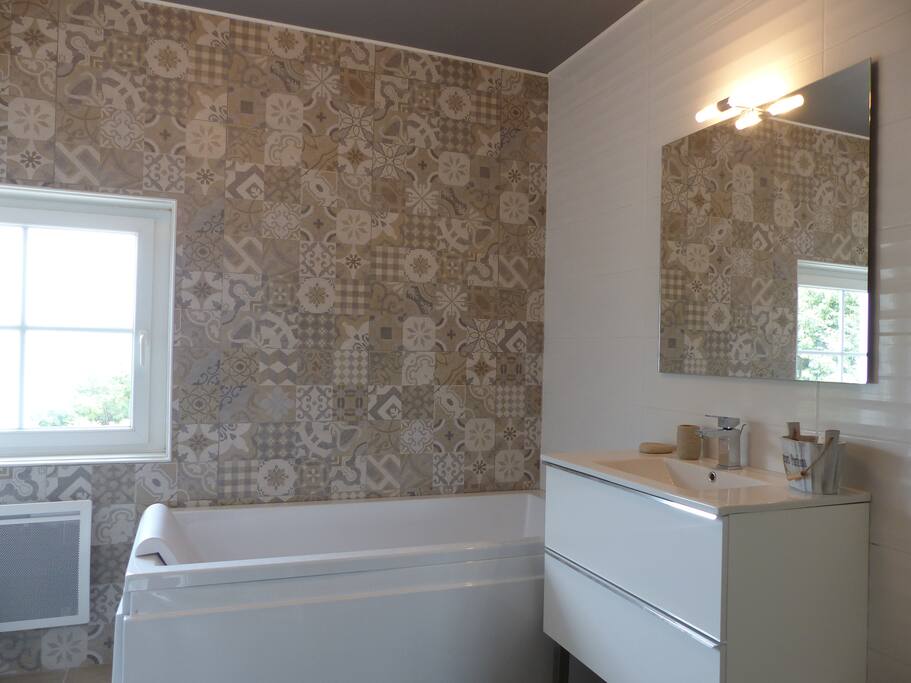 Salle de bains avec baignoire balnéo