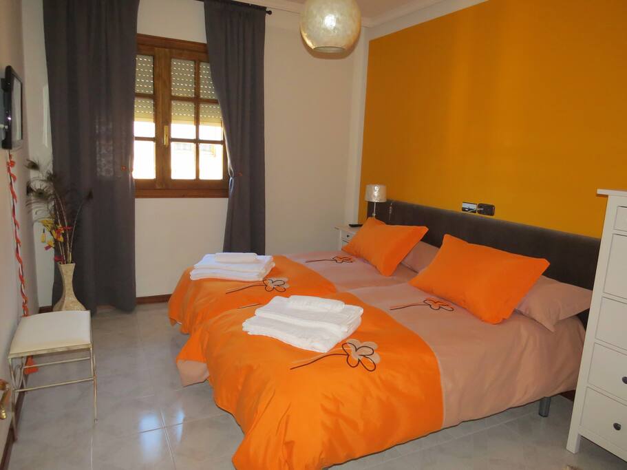 Habitaciones dobles con ropa de cama, toallas y TV