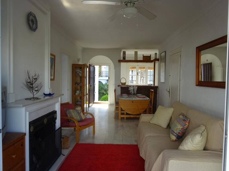 Salón con chimenea, sofá cama y TV