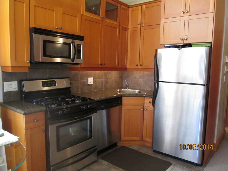 Kitchen area with stainless steel appliances. Heated tile throughout.