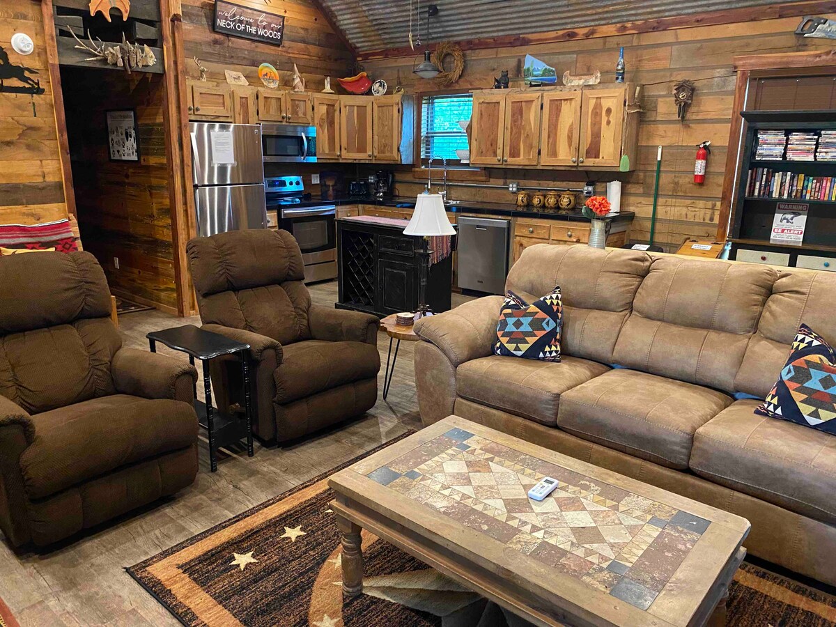 Woonkamer heeft slaapbank +2 ligstoelen. Keuken/eetkamer is op de achtergrond.