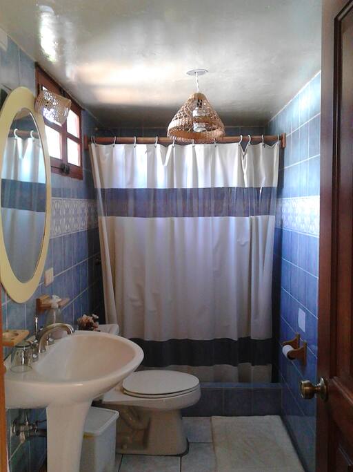 Baño amplio con agua caliente y luz natural.