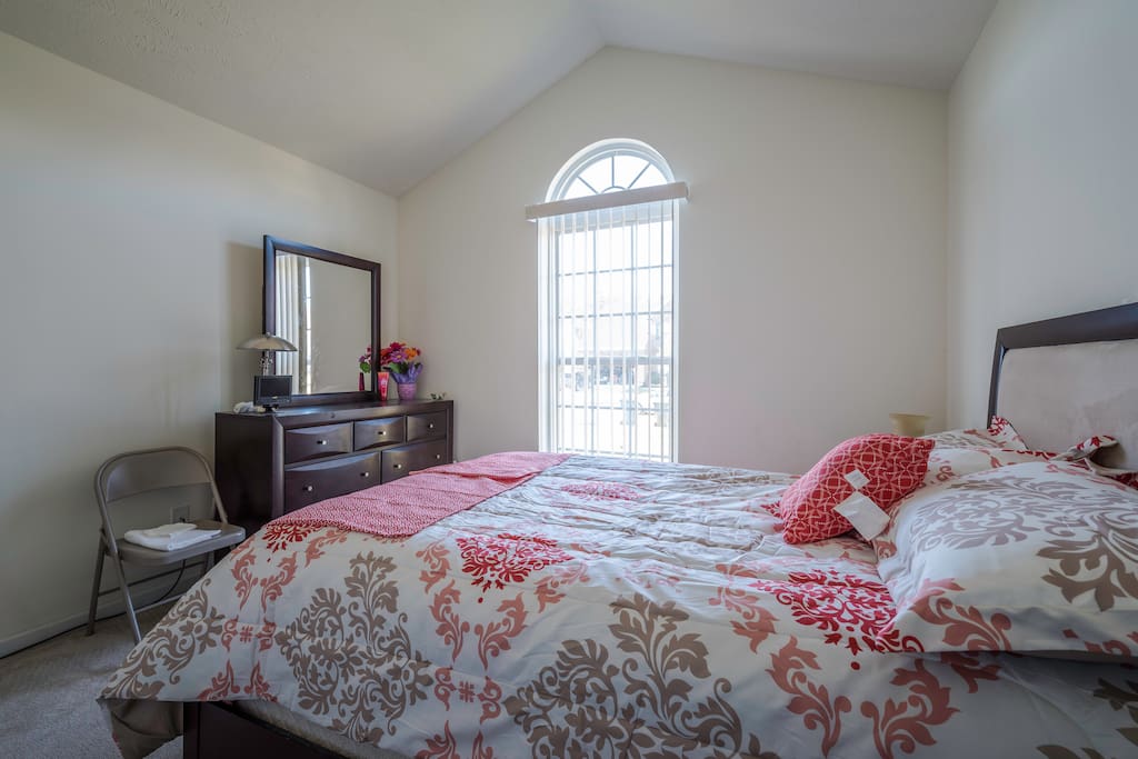 Bright and Sunny bedroom with a queen size bed.