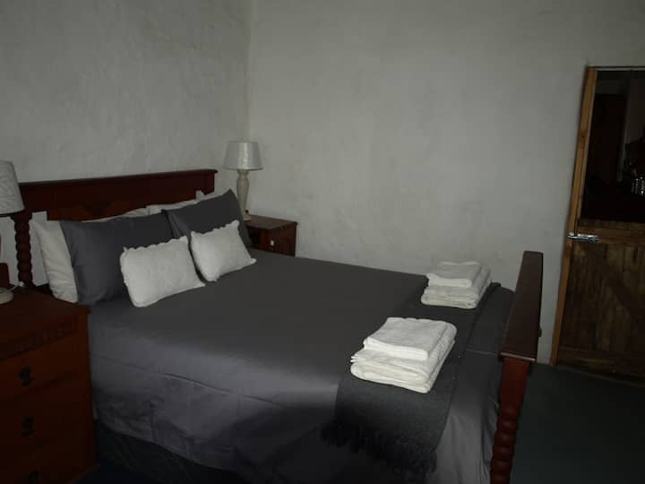 Dormitorio 2 con cama matrimonial en colores blanco y gris