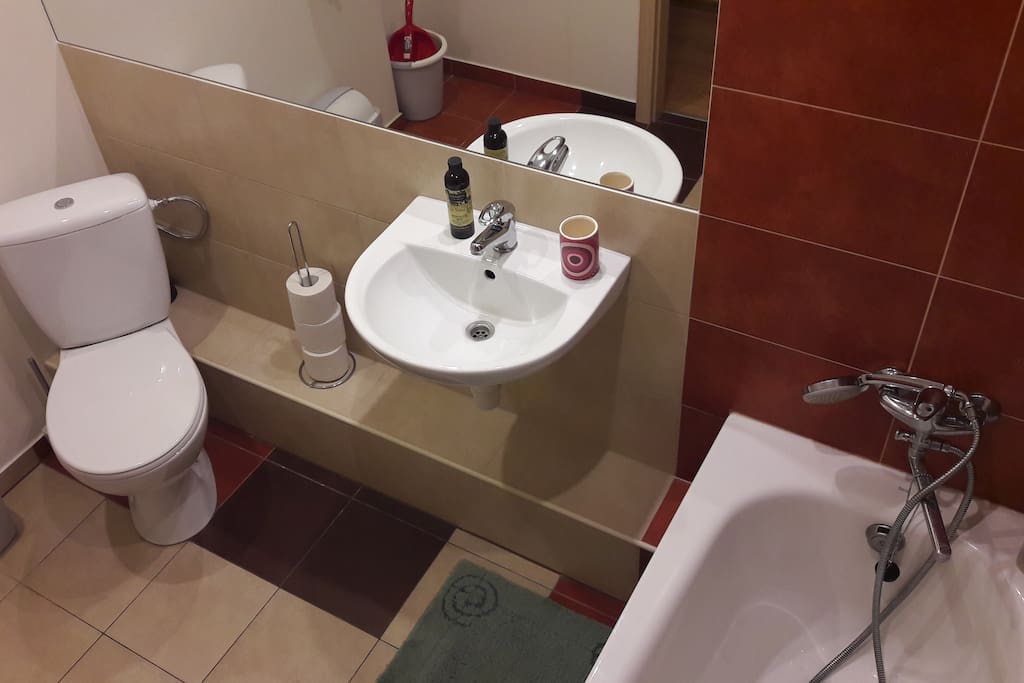 A clean bathroom with a bath and shower.