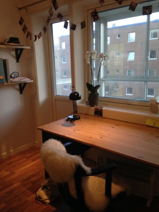 Skrivebord med utsikt ut på veranda og balkong