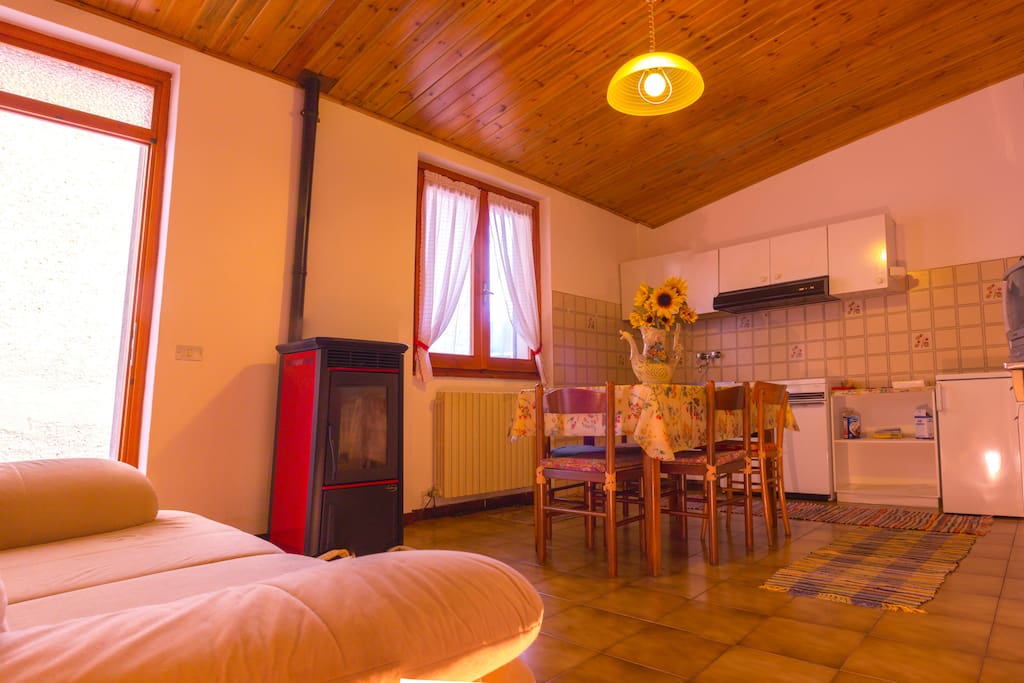 Zona giorno con stufa a pellet, cucina a vista, TV