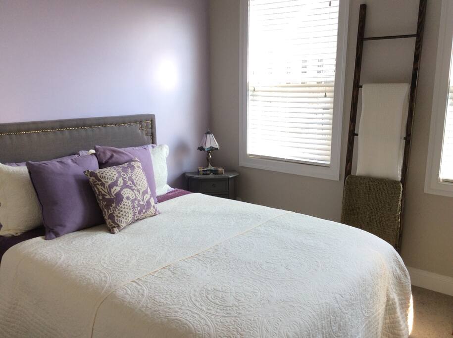 Bedroom with three large windows featuring a mountain view.