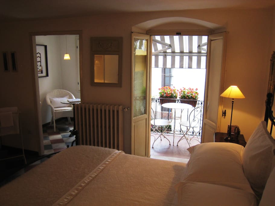Gorgeously atmospheric master bedroom made up with crisp white linens, with private sitting area (suitable for baby cot), French doors to balcony, adjacent bathroom and second bedroom